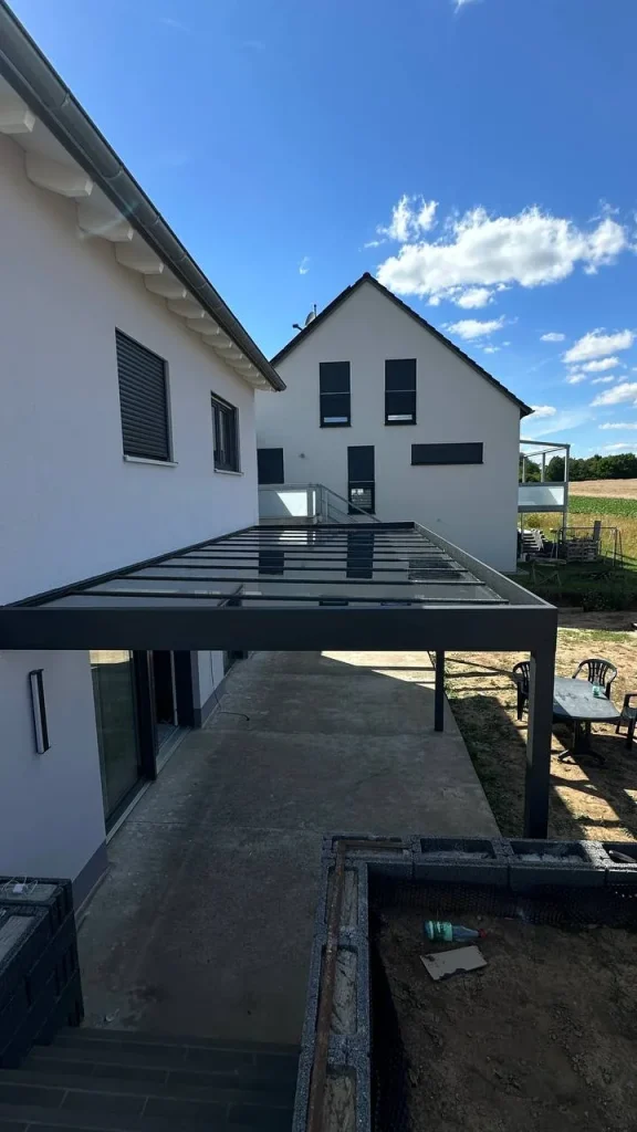 Alu-Terrassenüberdachung an der Hausfassade während der Bauphase