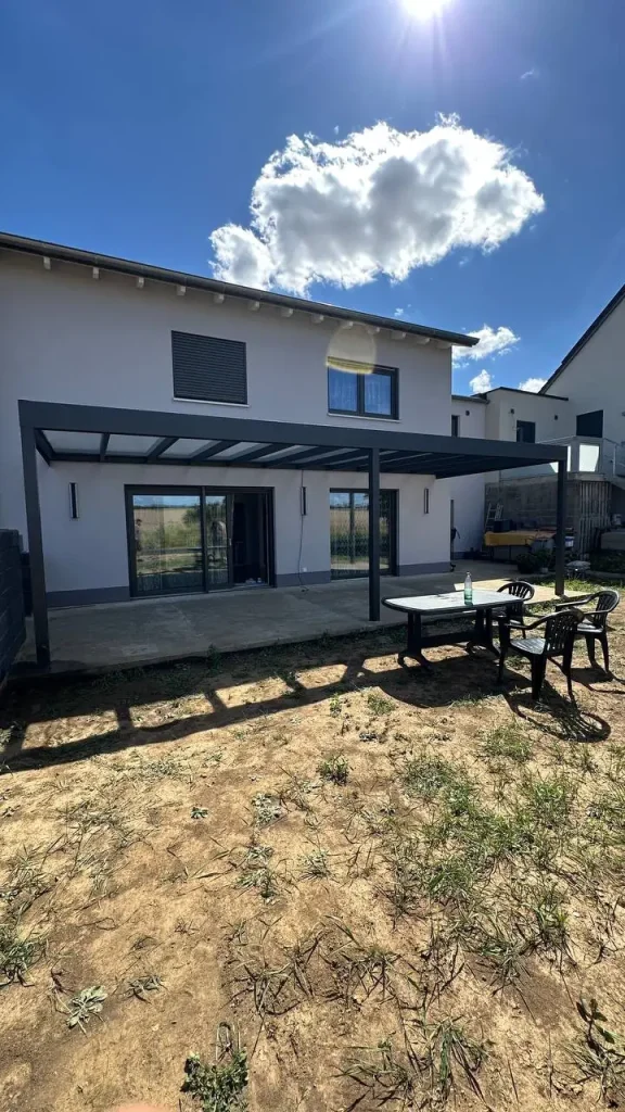 Alu-Terrassenüberdachung mit Sitzgruppe im noch unfertigen Garten