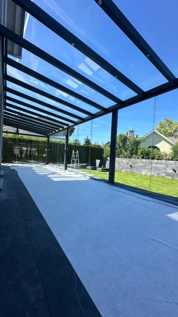 Terrassenüberdachung mit Glasdach, Terrasse während der Montage abgedeckt