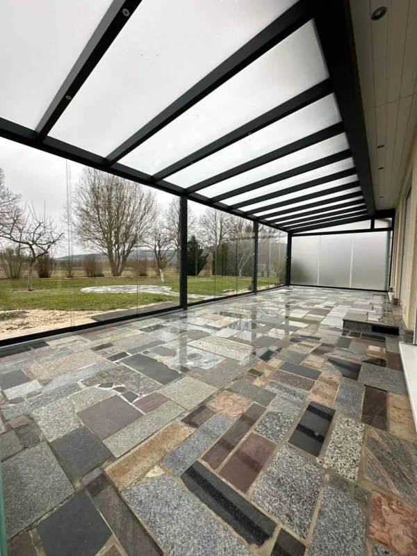 Blick unter das Glasdach des Kaltwintergartens entlang der Hausfassade