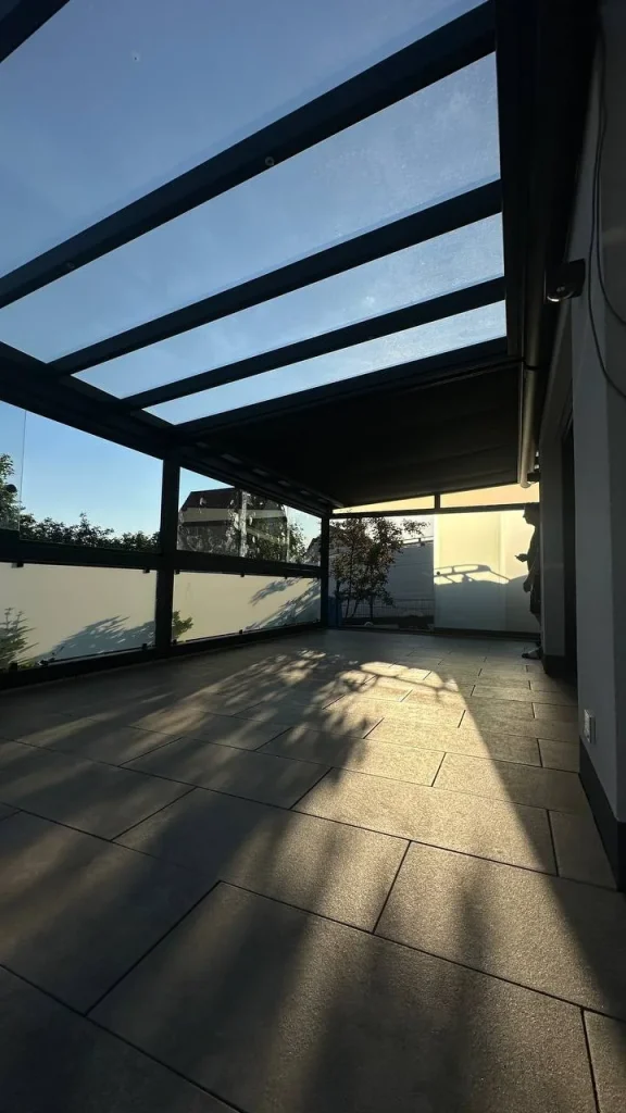 Innenansicht einer Terrassenüberdachung mit Glasdach im Sonnenlicht