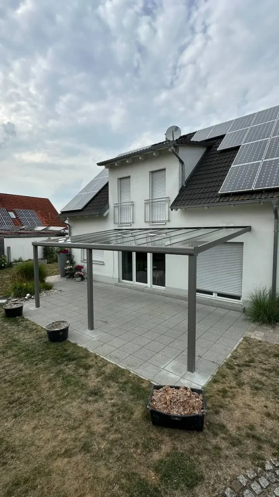 Alu-Terrassenüberdachung in Anthrazit an einem Haus mit Photovoltaikanlage