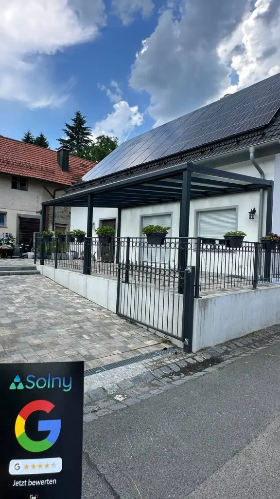 Alu-Terrassenüberdachung in Anthrazit an einem Haus mit Solaranlage