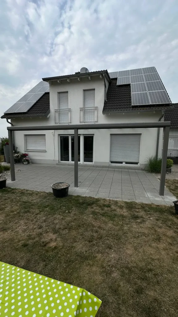 Alu-Terrassenüberdachung am Einfamilienhaus mit Rasenfläche