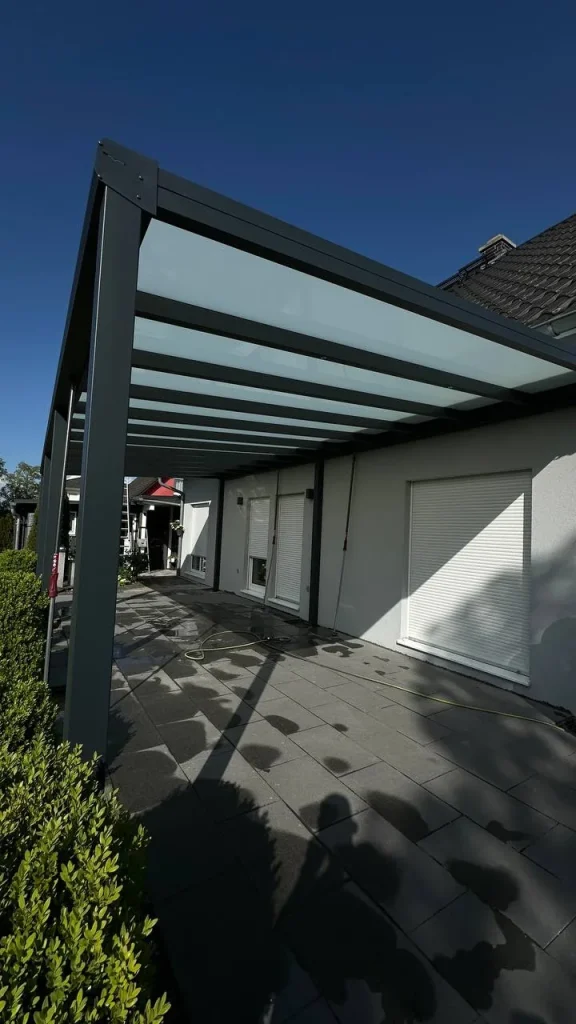Alu-Terrassenüberdachung in Anthrazit mit Glasdach an einem hellen Einfamilienhaus – Projekt von Solny