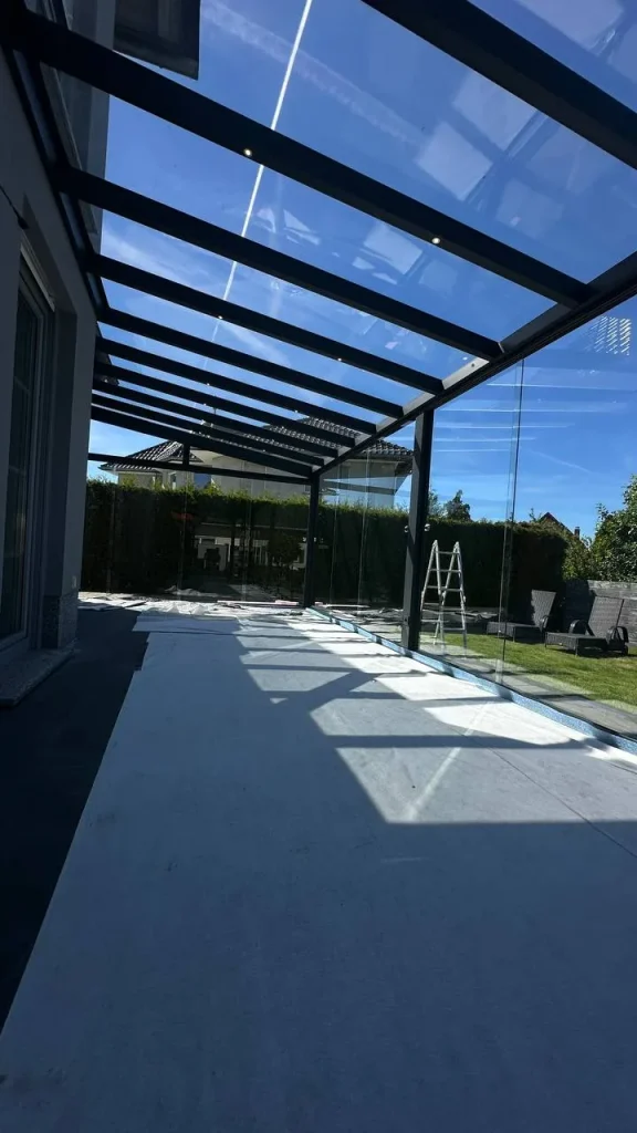 Terrassenüberdachung mit Glasdach über dem Weg während der Montage – Projekt von Solny