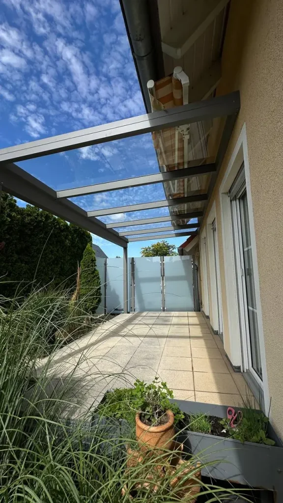 Terrassenüberdachung mit Glasdach und seitlichem Sichtschutzelement – Projekt von Solny