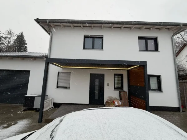 Einfamilienhaus mit angebauter Terrassenüberdachung im Schnee
