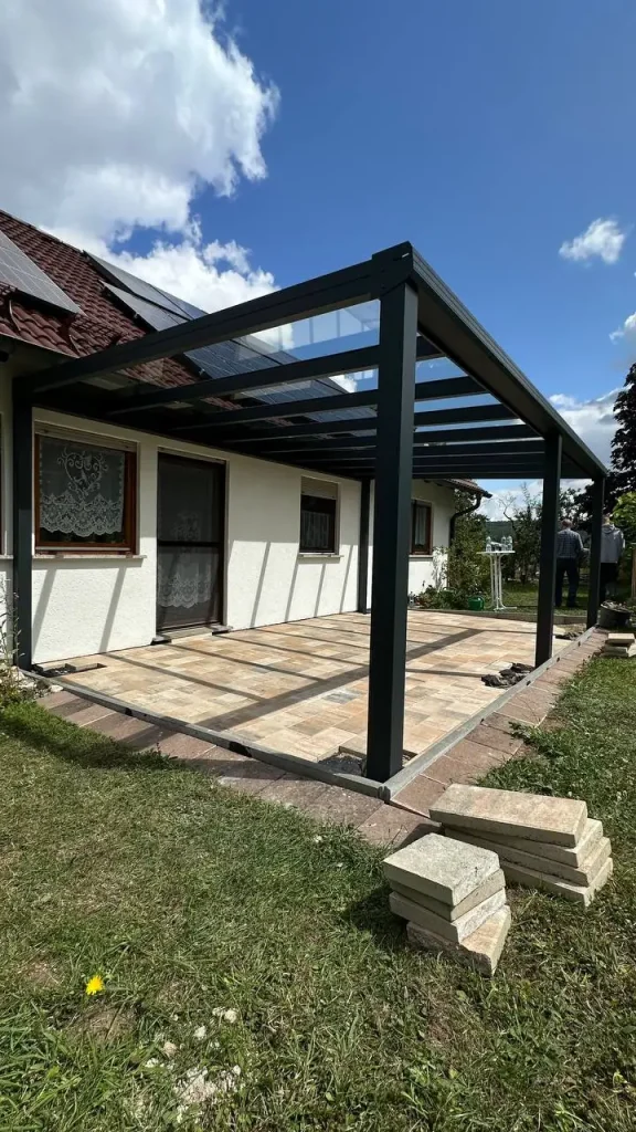 Aluminium-Terrassendach mit Glasdach neben der Wiese