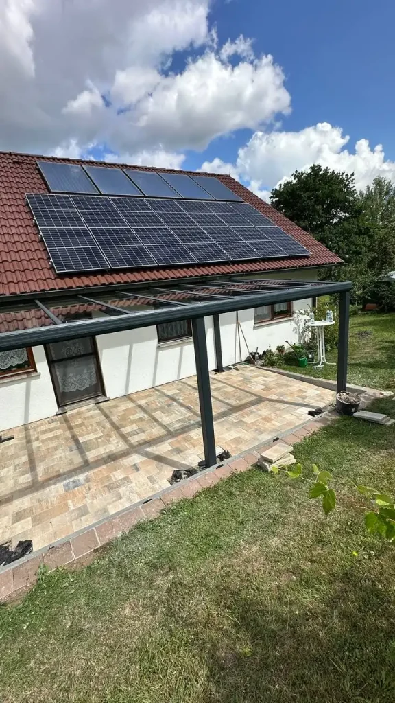 Aluminium-Terrassendach an einem Haus mit Natursteinplatten-Terrasse