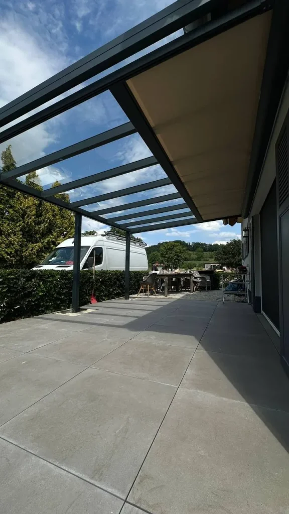 Terrassenüberdachung mit Glasdach und Sonnenschutz an der Zufahrt