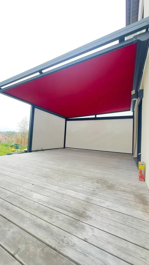 Terrassenüberdachung mit textilem Sonnenschutz über einer Holzterrasse