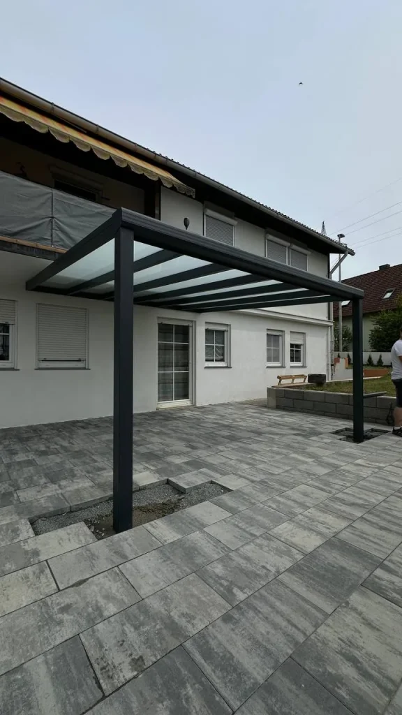 Terrassenüberdachung aus Aluminium mit Glasdach an einem hellen Haus – Projekt von Solny