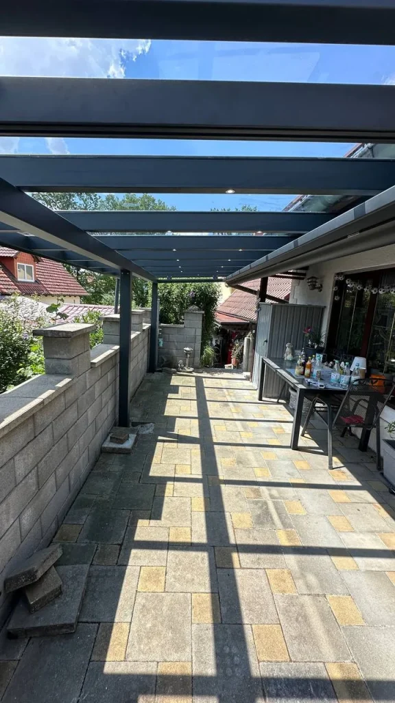 Lange Terrassenüberdachung mit Glasdach entlang einer Mauer – Projekt von Solny