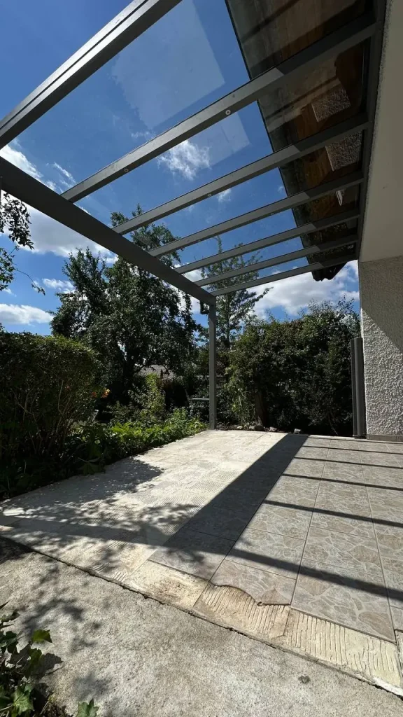 Terrassenüberdachung aus Aluminium mit Glasdach an einer Hausecke über der Terrasse – Projekt von Solny