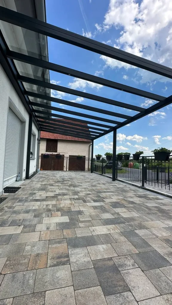 Terrassenüberdachung aus Aluminium mit Glasdach mit Blick auf das Nachbardach