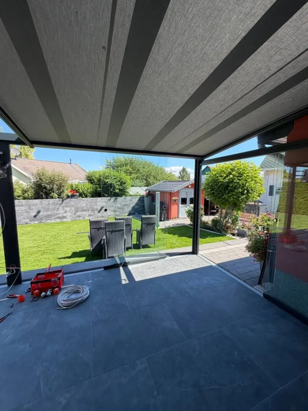 Terrassenüberdachung aus Aluminium mit ausfahrbarem Sonnenschutz während der Montage – Projekt von Solny