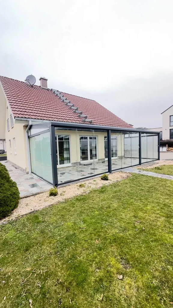 Verglaste Terrasse / Kaltwintergarten mit Glasseitenwand in Anthrazit am Einfamilienhaus – Projekt von Solny