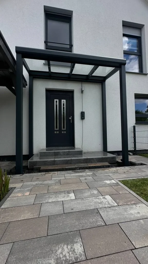 Vordach aus Aluminium mit Glasdach über der Haustür – Projekt von Solny
