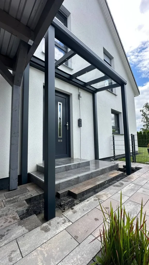 Vordach aus Aluminium über der Haustür, Eingangsstufen im Rohbau